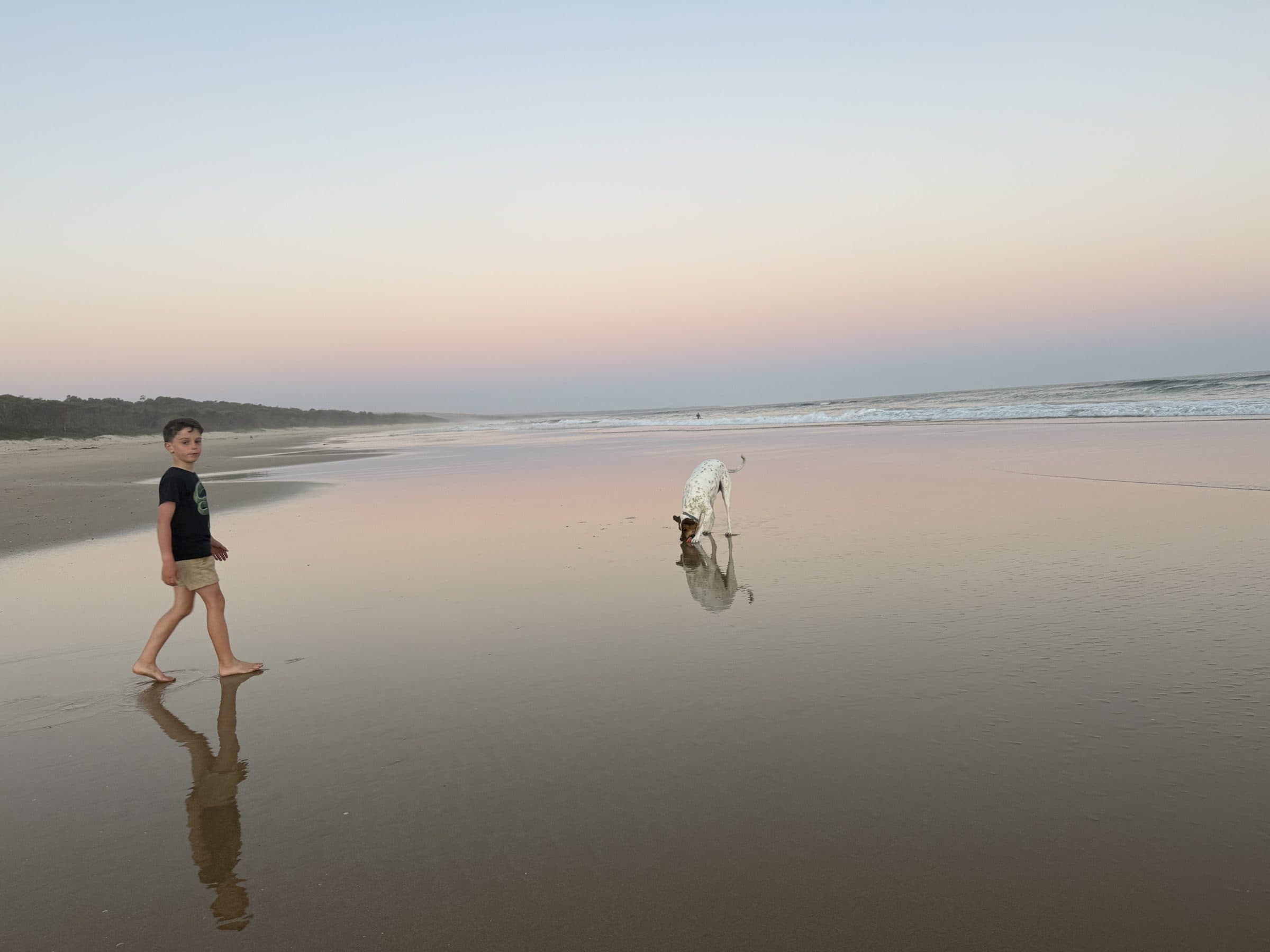 A boy and a dog on the beach at sunset, Cape Conran